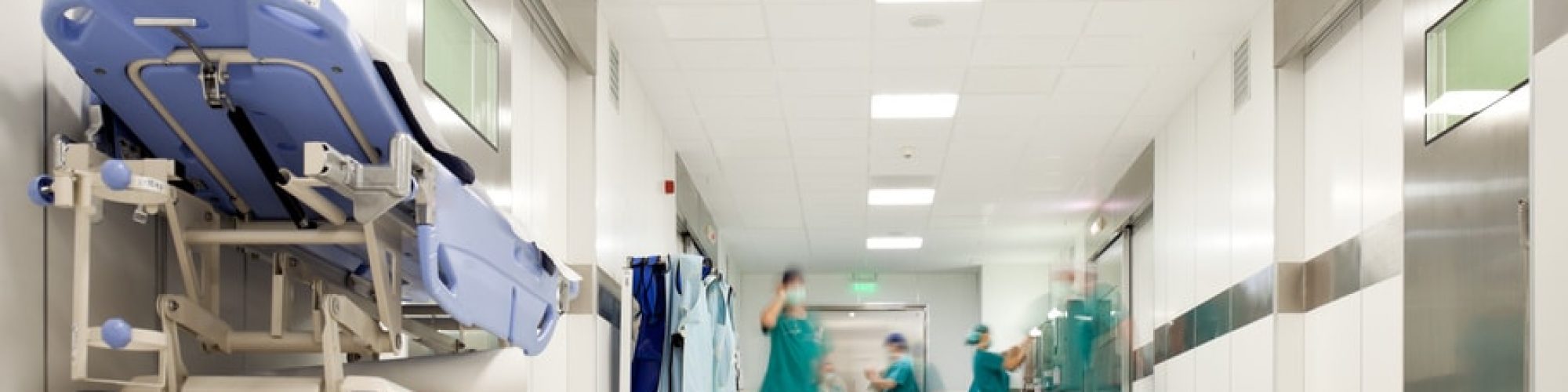 Blurred figures of people with medical uniforms in hospital corridor
